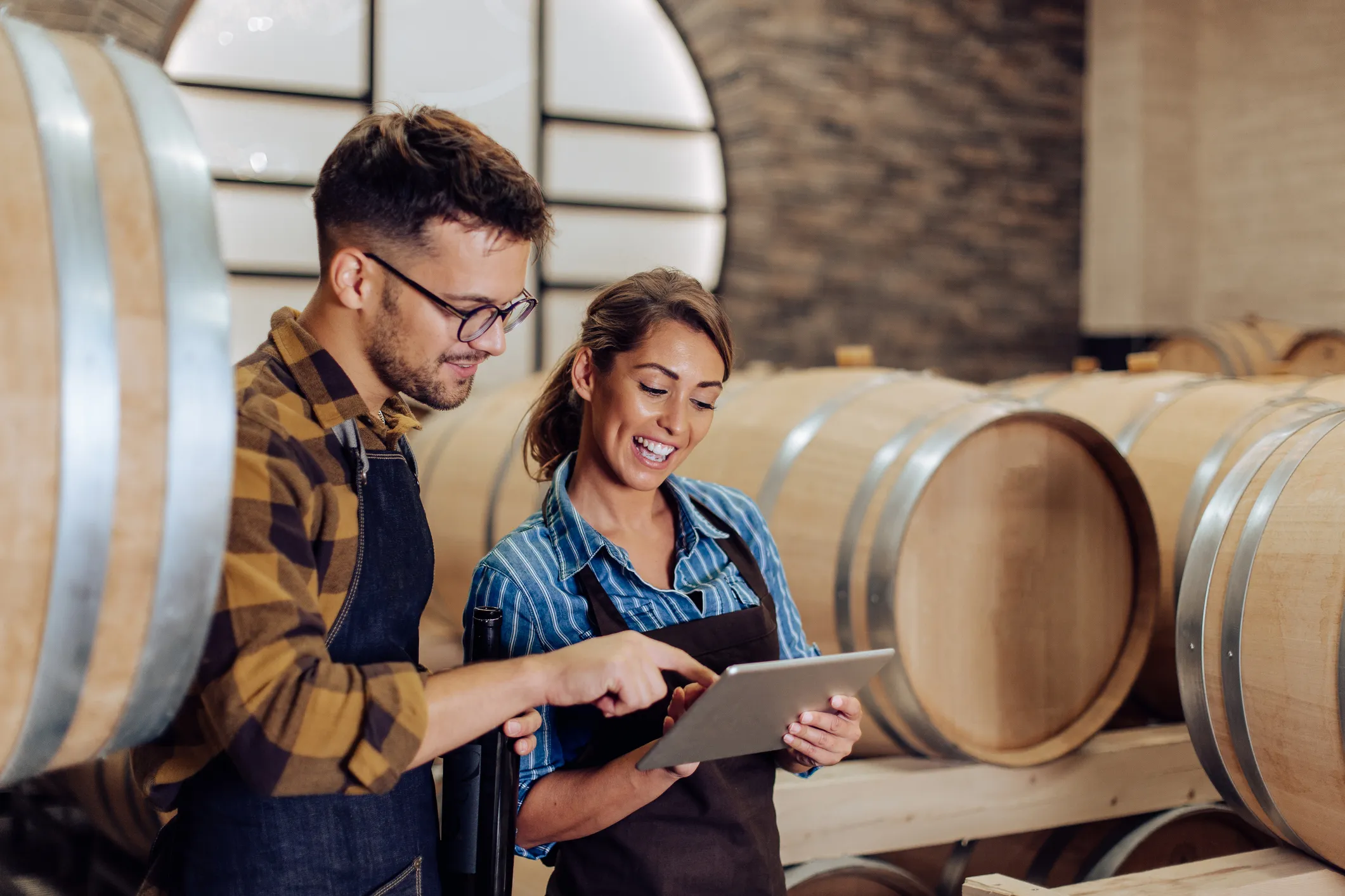 Two people looking at a tablet at a winery