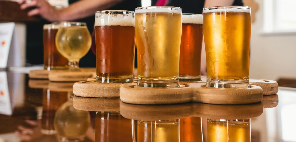 Flights of craft beer served on wooden paddles in a taproom